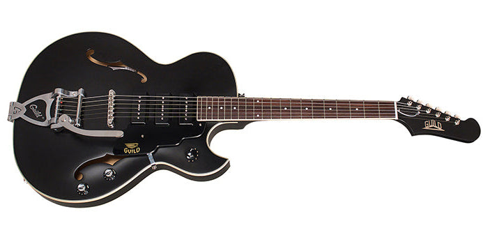 Black hollow-body electric guitar with silver hardware, wooden fretboard, and Guild logo on the headstock and pickguard.