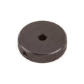 Black circular knob with textured edges and a central hole, shown on a white background.