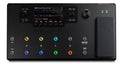 Top view of a black multi-effect guitar pedalboard with a screen, knobs, footswitches, and an expression pedal.