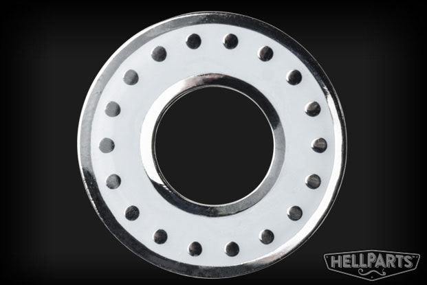 Round metal washer with white center and evenly spaced rivets around the edge on a black background.