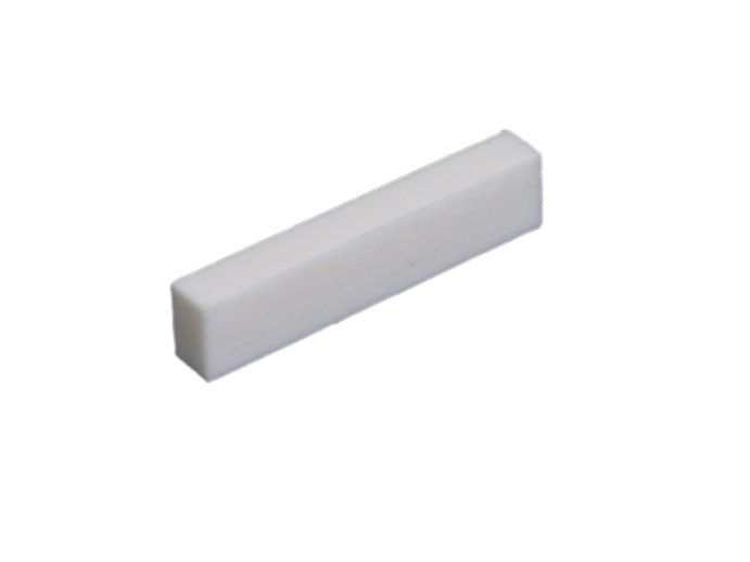 Single white rectangular block, likely a flat bottom blank nut part for string instruments.