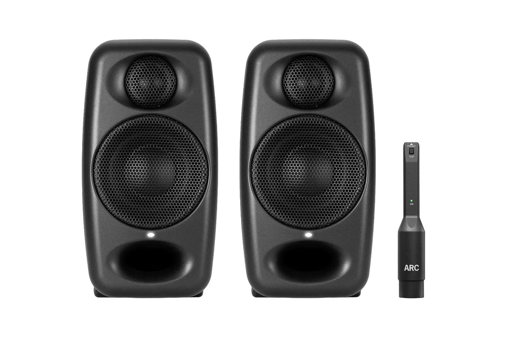 Pair of black studio monitor speakers with a small black ARC device beside them.
