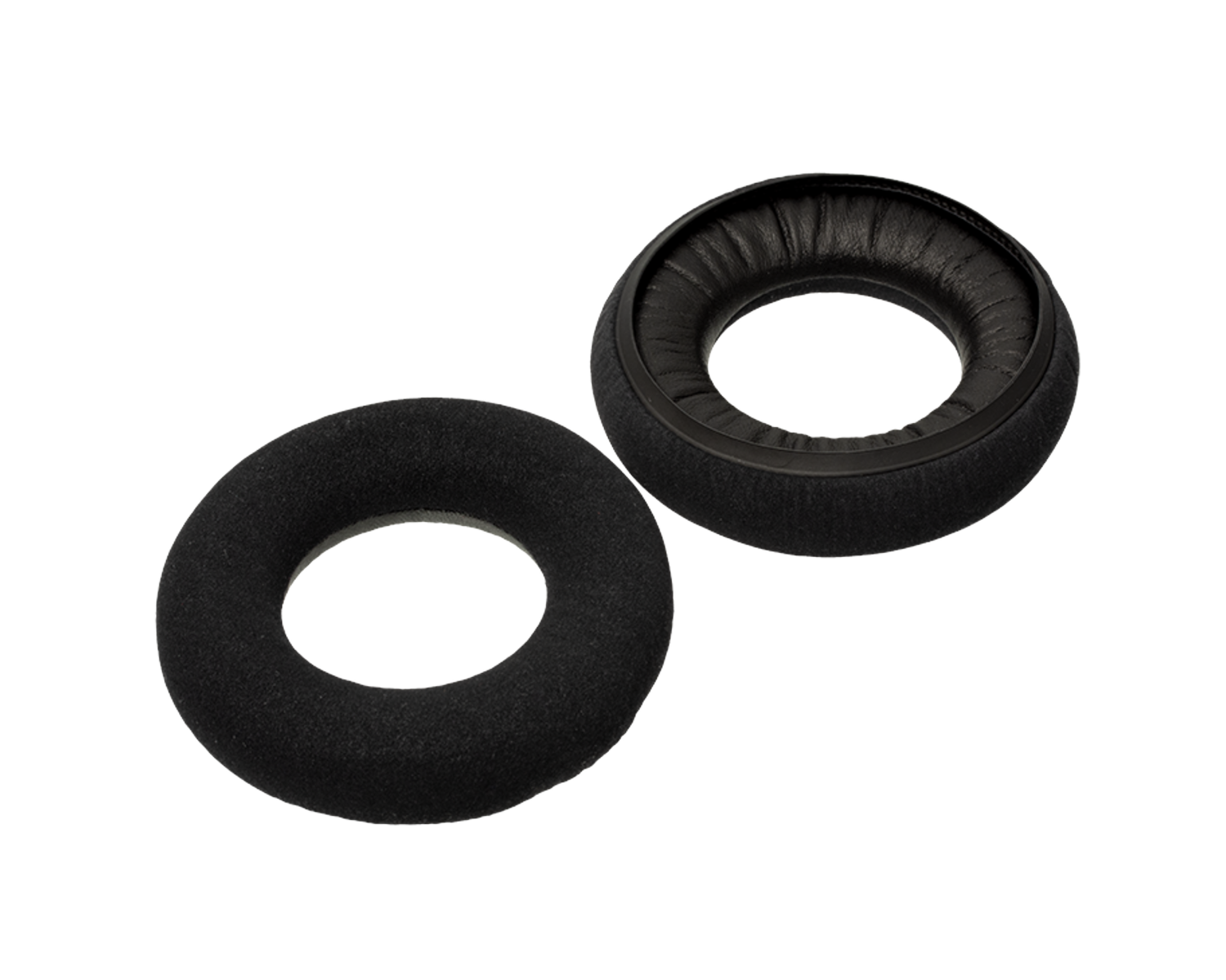 Two black round ear pads for headphones, one showing fabric side and the other showing leather-like side.