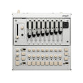 Top-down view of a silver synthesizer with numbered metal levers, multiple knobs, buttons, and labeled controls.