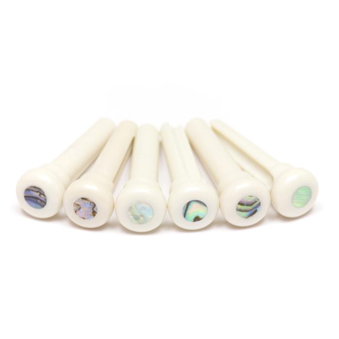 Six white bridge pins with round iridescent decorative dots on top arranged in a row.