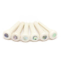 Six white bridge pins with colorful abalone inlay dots arranged in a row.
