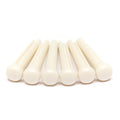 Seven white plastic pins arranged in a row on a white background.