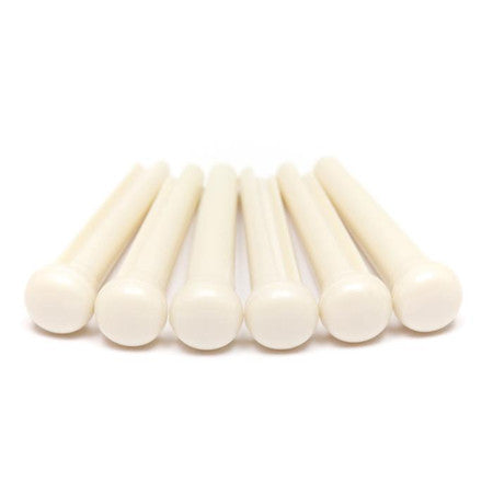 Seven white plastic pins arranged in a row on a white background.