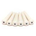Six white cylindrical pins with black dots on one end arranged in a row on a white background.