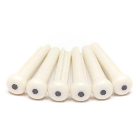 Six white cylindrical pins with black dots on one end arranged in a row on a white background.