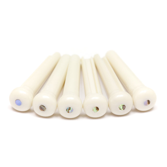 Six white bridge pins with multi-colored inlays arranged in a row on a white background.