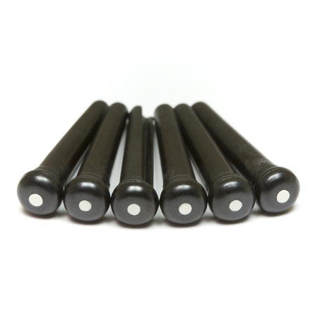 Six black bridge pins each with a white dot on top laid side by side.