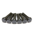 Six black cylindrical bridge pins arranged horizontally on a white surface.