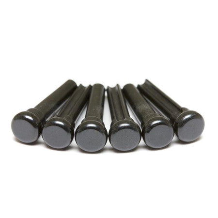 Six black cylindrical bridge pins arranged horizontally on a white surface.