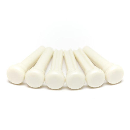 Six white plastic bridge pins arranged in a row on a white background.
