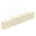 Close-up view of a cream-colored slotted nut for a stringed instrument with five string slots.