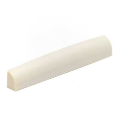 Whiteish rectangular guitar nut with a curved top and flat base on a white background.