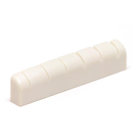 White slotted guitar nut with six string slots visible in a close-up side view.