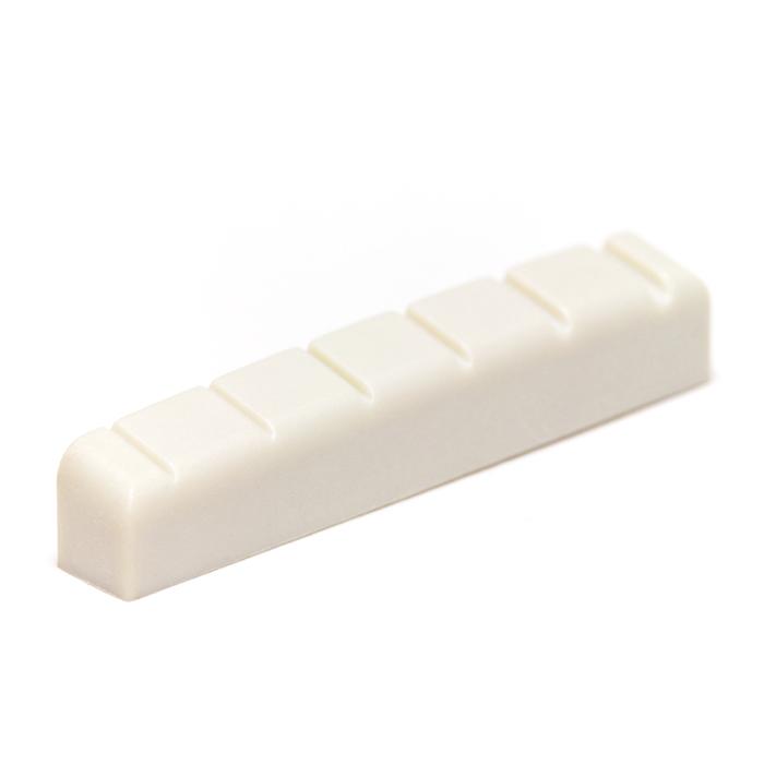 White slotted guitar nut with six slots designed for guitar strings.