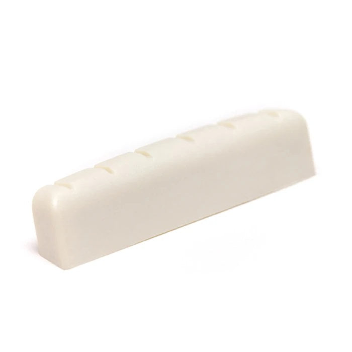 Off-white slotted guitar nut piece photographed on a white background.