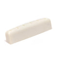 Off-white slotted guitar nut piece photographed on a white background.
