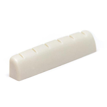 Off-white slotted guitar nut with six slots visible, shown from an angled side view.