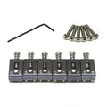 Set of six black metal guitar saddles with six screws and a hex key on a white background.