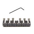 Set of six black metal guitar saddles with screws and a black hex wrench on white background.