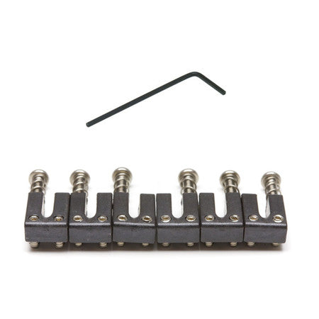 Set of six black metal guitar saddles with screws and a black hex wrench on white background.