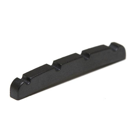 Black four-string nut with slots for string placement, likely for a guitar or bass instrument.
