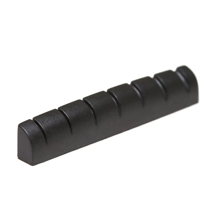 Black guitar nut with seven string slots, viewed at an angle on a white background.