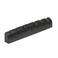 Black guitar nut with seven string slots, viewed at an angle on a white background.
