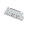 Chrome metal guitar bridge plate with multiple circular holes on a white background.
