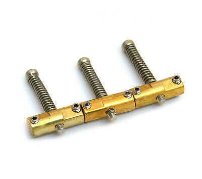 Set of three brass saddles each with a spring and screws, arranged in a row on a white background.