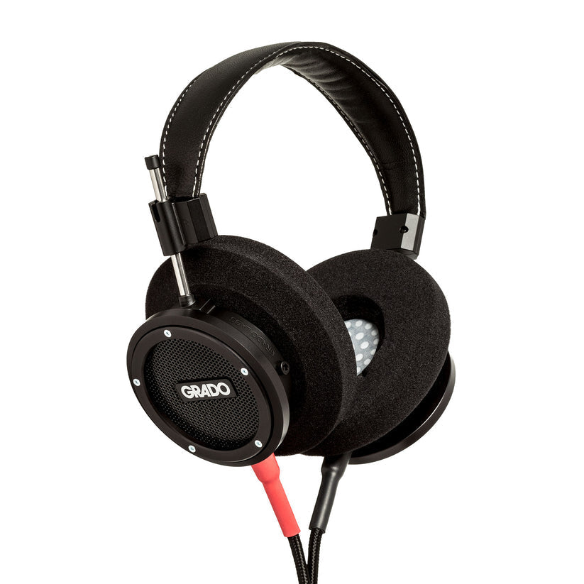 Black over-ear headphones with foam ear pads, metal headband supports, and a red and black audio cable.