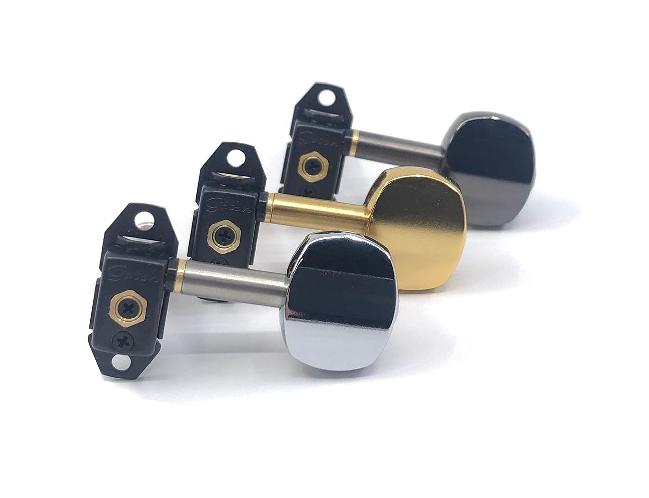 Three guitar tuning machine heads in black, gold, and silver finishes arranged angled on a white background.