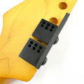Black machine head pin drill locator tool attached to light brown wooden guitar headstock with drill guide holes.