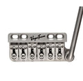 Silver metal guitar bridge with six saddles and attached tremolo arm labeled VegaTrem.