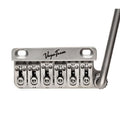 Silver metal tremolo bridge with six saddles and a tremolo arm, marked VegaTrem.