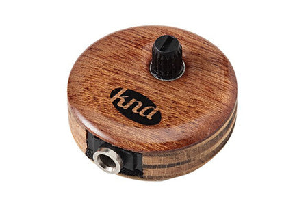 Round wooden piezo pickup with a black control knob and a quarter-inch audio jack connector.