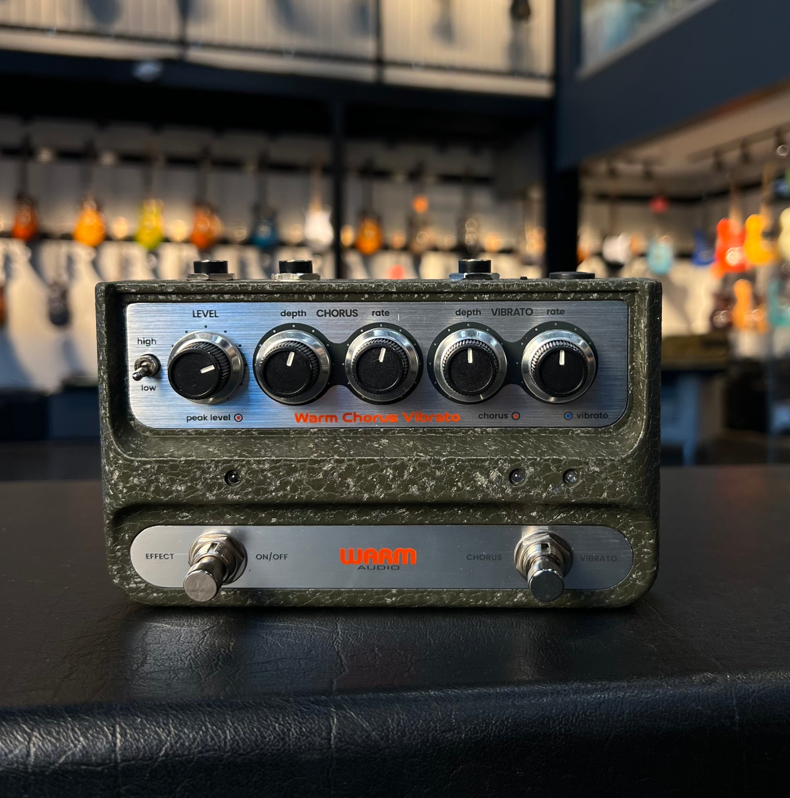 Front view of a green textured Warm Audio pedal with knobs and footswitches labeled chorus and vibrato controls.