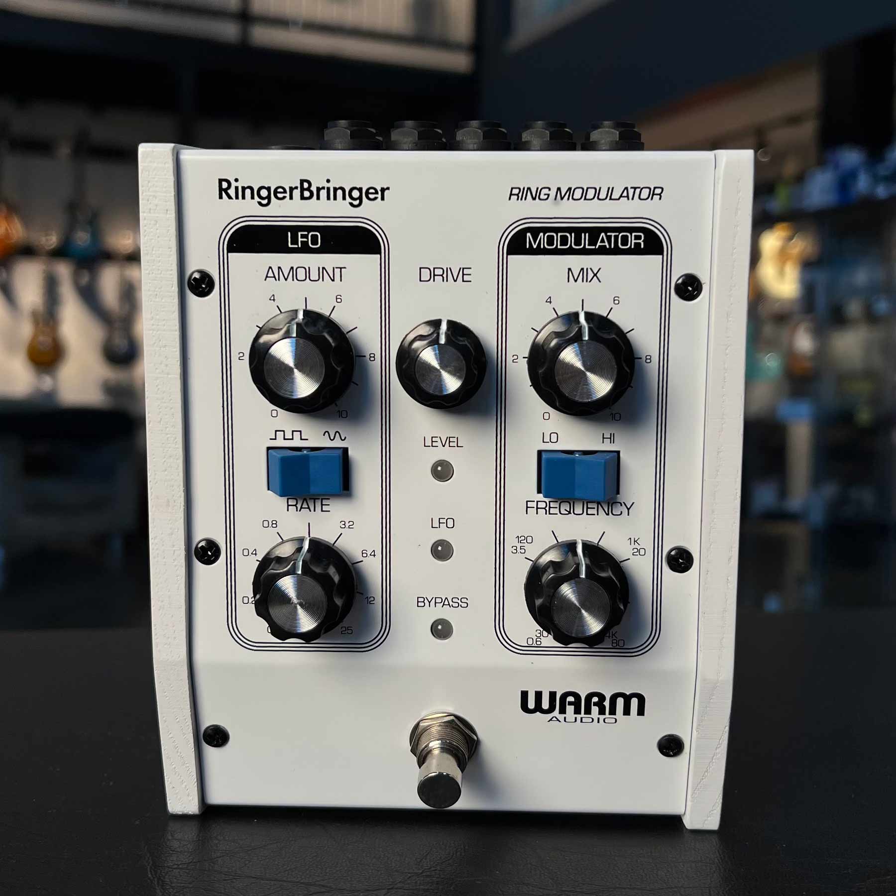 White Warm Audio RingerBringer ring modulation pedal with knobs, toggle switches, footswitch and indicator lights.