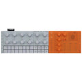 Top view of a Yamaha sequencer with gray and orange panels featuring knobs, sliders, pads, buttons, speaker, and input/output ports.